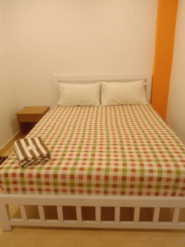 a bed with a checkered blanket on it at Jasmine Villa Soi Buakhao in Pattaya Central