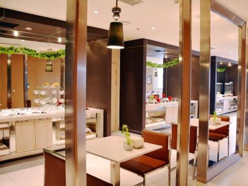 - un restaurant avec une table et des chaises dans la chambre dans l'établissement Jinjiang Inn Siping Pingdong Road Wada Square, à Siping
