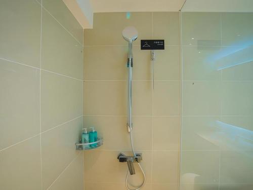 a shower with a shower head in a bathroom at City Comfort Inn Hechi Tian'E Bus Terminal in Nandan