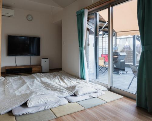 Schlafzimmer mit einem Bett, einem TV und einem Balkon in der Unterkunft Private stay Peaceful - Vacation STAY 18247 in Minamiawaji