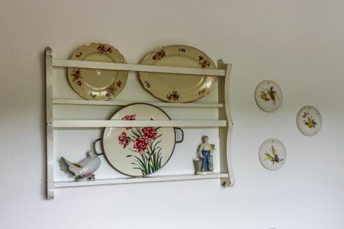 a shelf with plates and dishes on a wall at Naturperlen in Rødekro