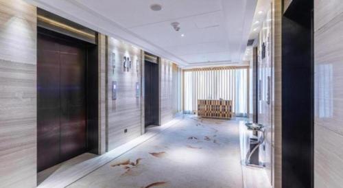 a hallway with a door and a chair in a building at Xincheng hotel in Zunyi