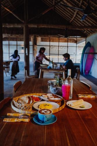 un tavolo di legno con piatti di cibo sopra di Gili Dua Resort a Sekongkang