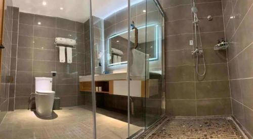 een badkamer met een glazen douche en een toilet bij GreenTree Inn Heze Shan County New Bus Station in Shan