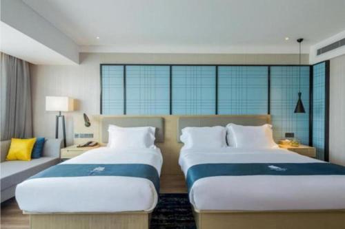 a hotel room with two beds and a couch at Echarm Hotel Changsha Xiangya Fushan in Changsha