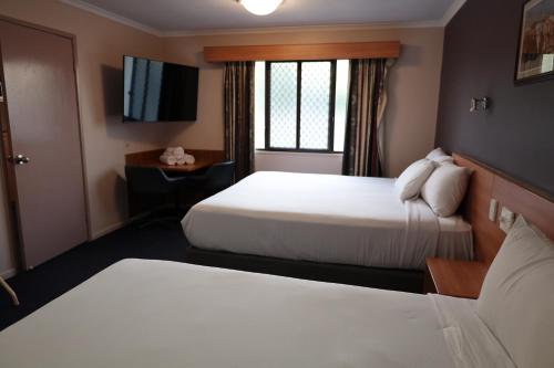 Ένα ή περισσότερα κρεβάτια σε δωμάτιο στο SunPalms Motel