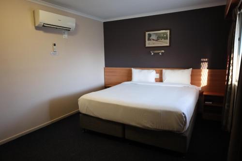 Ένα ή περισσότερα κρεβάτια σε δωμάτιο στο SunPalms Motel