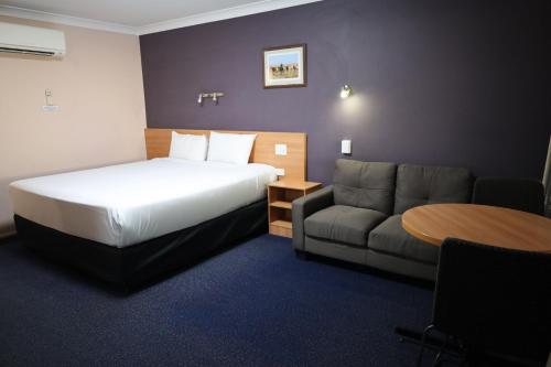 a hotel room with a bed and a couch at SunPalms Motel in Rockhampton