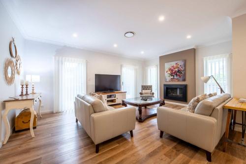 un soggiorno con due divani e una TV di Lakeside on Southlakes - Family Entertainer a Dubbo