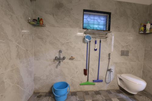 een badkamer met een toilet en schoonmaakspullen aan de muur bij Basaghara On Chilika - A Bungalow in Mangalajodi in Jāmb