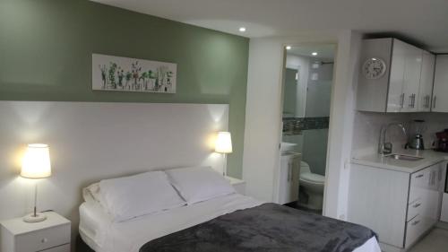 Un dormitorio pequeño con una cama y un baño. en ApartaSuite 2 a 3 personas cerca club campestre, en Medellín