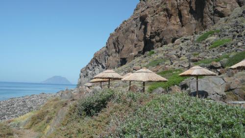 a group of umbrellas on a hill next to the ocean at La Casa del Pescatore in Filicudi