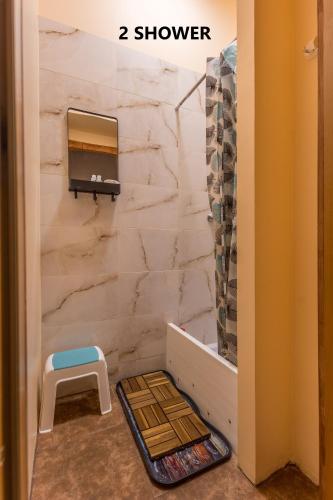 a bathroom with a marble wall with a mirror and a stool at Central at Kaunas Hostel in Kaunas