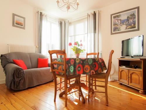 ein Wohnzimmer mit Tisch und Stühlen und einer Couch in der Unterkunft Cozy Garden Retreat Malemort in Malemort-sur-Corrèze