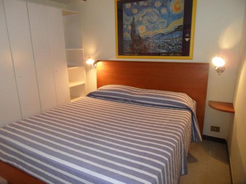 ローマにあるColosseum Cottageの小さなベッドルーム(青と白のストライプのベッド付)