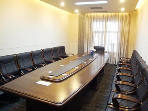 a conference room with a long table and leather chairs at Jinjiang Inn Daqing Xincun Development Zone in Daqing