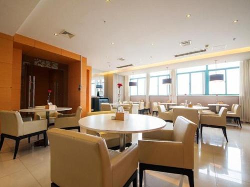 a restaurant with tables and chairs and windows at Jinjiang Inn Nantong Gongnong Road in Nantong