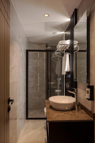 a bathroom with a white sink and a shower at Mery Hotel İstanbul in Istanbul