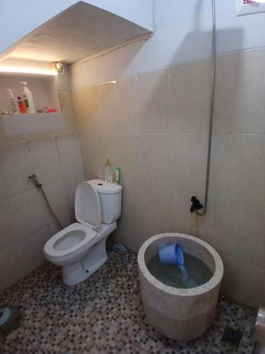 La petite salle de bains est pourvue de toilettes et d'une baignoire. dans l'établissement Homestay keluarga solo or solo's family homestay, à Purwosari