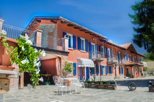 un bâtiment avec des chaises et des tables devant lui dans l'établissement B&B La Buonora, à Sinio