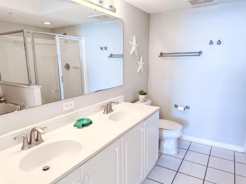 a bathroom with a sink and a toilet and a mirror at Ashworth 905 in North Myrtle Beach