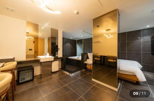a bathroom with a bed and a sink and a tub at Motel Cookie in Seoul