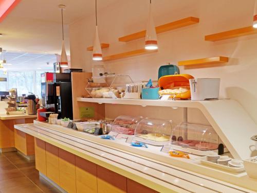 a kitchen with a counter with food on it at ibis budget Hotel BONN SÜD Königswinter in Königswinter