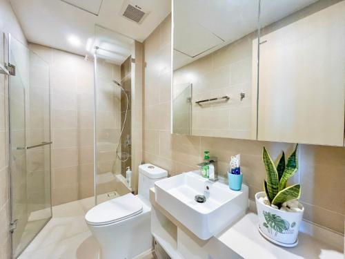 Un baño con lavabo, inodoro y ducha. en The Sóng Vũng Tàu Apartment, en Vung Tau