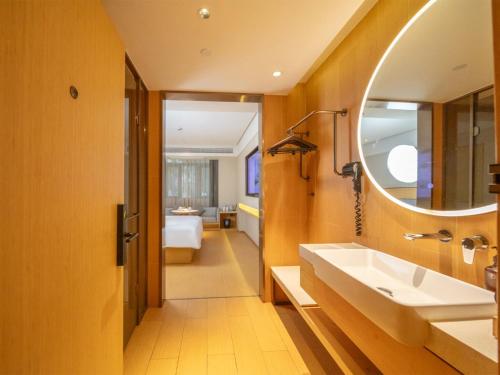 ein Badezimmer mit Waschbecken und Spiegel in der Unterkunft JI Hotel Shanghai Central Ring Bailian Meichuan Road (formerly Meichuan Road Branch) in Shanghai