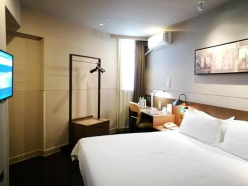 a hotel room with a bed and a television at Jinjiang Inn Select Yancheng Dongtai Gulou Road Pedestrian Street in Dongtai