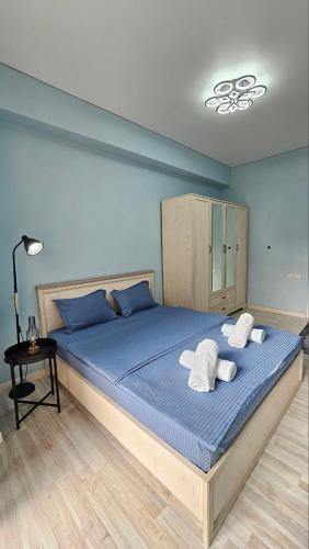 una camera da letto con un grande letto blu con due cuscini di Lamiya a Almaty
