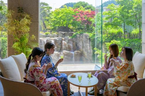 a group of people sitting around a table with drinks at Tendo Hotel in Tendo