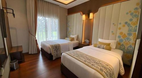 a hotel room with two beds and a window at Putri Duyung Ancol in Jakarta