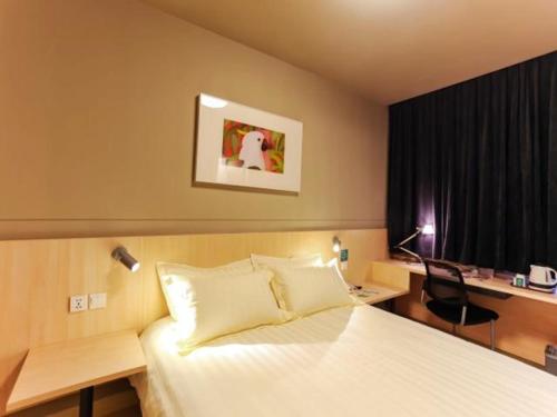 a bedroom with a bed and a desk with a computer at Jinjiang Inn Shanghai Baoshan Youyi Road in Baoshan