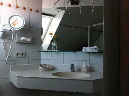 a bathroom with a sink and a mirror at Hotel Seeperle in Langenargen
