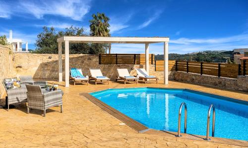 a swimming pool with chairs and a gazebo at Ferienhaus Für 16 Personen In Episkopi, Kreta West Kreta in Episkopí- Rethimno