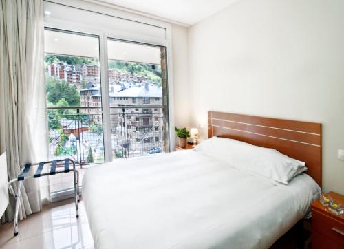 a bedroom with a large bed and a large window at Andorra4days Canillo in Canillo