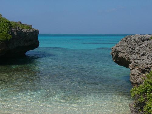 a view of the ocean between two large rocks at Seaside House Nirai in Miyako Island