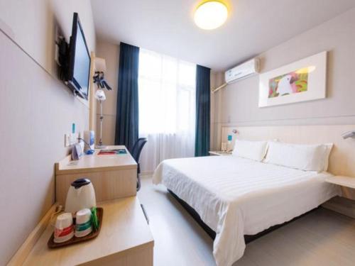 a hotel room with a bed and a television at Jinjiang Inn Xi'an Giant Wild Goose Pagoda in Xi'an