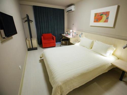 a bedroom with a white bed and a red chair at Jinjiang Inn Shanghai Hongqiao Hinge National Exhibition Centre in Shanghai