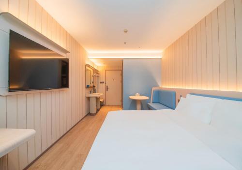 Ένα ή περισσότερα κρεβάτια σε δωμάτιο στο Hanting Hotel Shanghai Gucun Park Subway Station