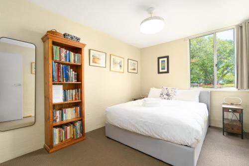 1 dormitorio con 1 cama y estantería con libros en Artful Kingston Stay with Personal Touch - Hosted by Canstay, en Kingston 