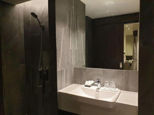 a bathroom with a sink and a shower and a mirror at XOTEL in Ban Non Muang