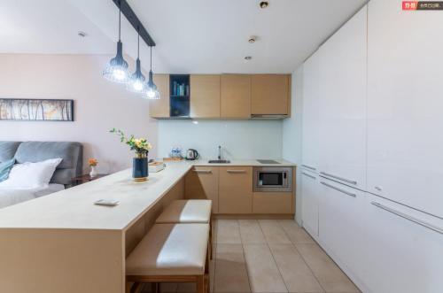 a small kitchen with a counter and a couch at Qingdao Tinglan Hotel Apartment (Wusi Square Mixc City Branch) in Qingdao