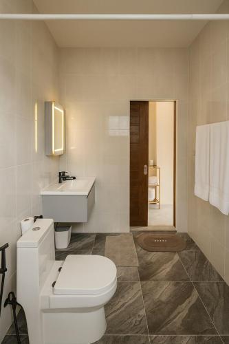 a white bathroom with a toilet and a sink at NEW! Sunset & Seaview Pool Villa in Ko Ma
