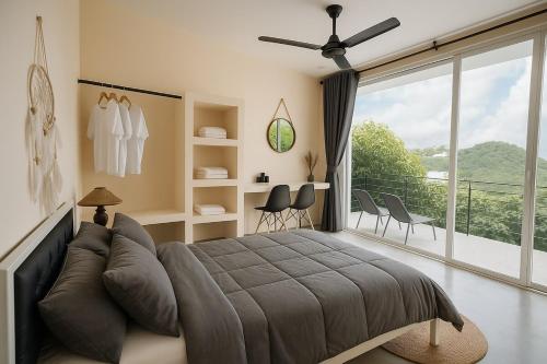 ein Schlafzimmer mit einem großen Bett und einem Balkon in der Unterkunft NEW! Sunset & Seaview 4BR 5BA Pool Villa in Ko Ma