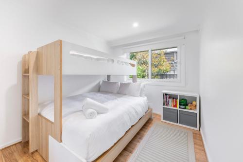 a white bedroom with a bunk bed and a window at Rye Retro Modern Remix in Rye