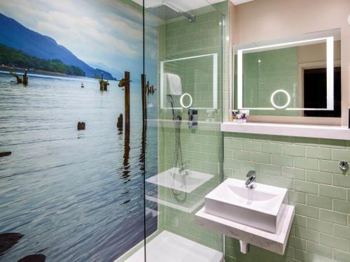 a bathroom with a sink and a glass shower at Mercure Inverness Hotel in Inverness
