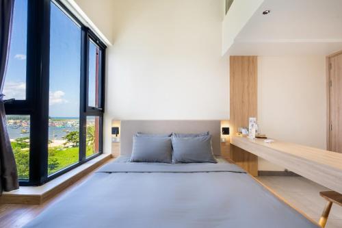 a bedroom with a large bed and a large window at The Rebirth Apartment Binh Chau Ho Tram in Bà Rịa