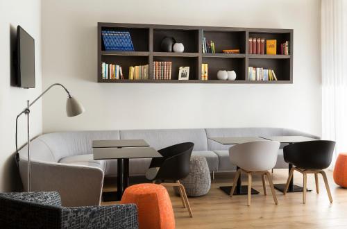 a living room with a couch and a table and chairs at Citadines Presqu'île Lyon in Lyon